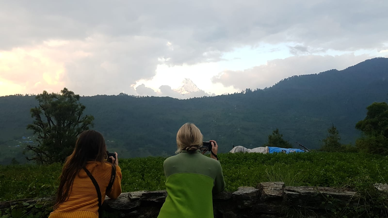 Two girls taking photos of mountains